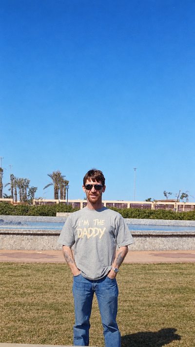 Standing outdoors in a t-shirt reading I’m the Daddy.